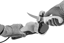 Image of ProductInUse. Shown in Use with Knife. Front orientation. Blade Sharpeners. Electric Blade Sharpeners, For Sharpening Knives and Scissors.