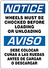 Image of Product. Front orientation. Signs. Plant and Shipping Dock Signs, Notice—Wheels Must Be Chocked Before Loading or Unloading/Aviso—Debe Colocar Cunas A Las Ruedas Antes De Cargar O Descargar (English/Spanish).